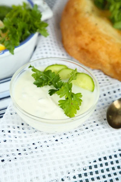 Iogurte de pepino em tigela de vidro e pão caseiro, em guardanapo de cor, em fundo de madeira — Fotografia de Stock