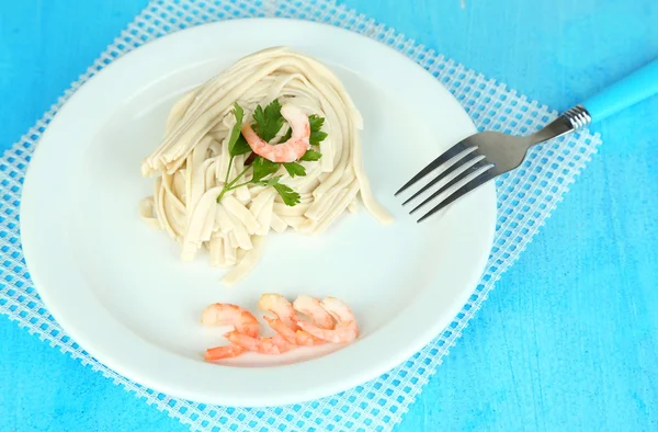 Pasta med räkor på vit platta, på trä bakgrund — 图库照片