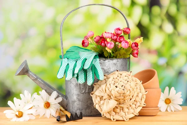 Gartengeräte und Blumen auf Holztisch, im Freien — Stockfoto