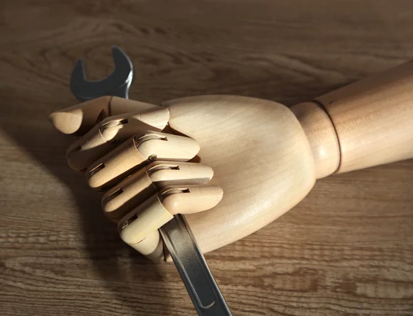 Llave en mano de madera sobre fondo de madera — Foto de Stock