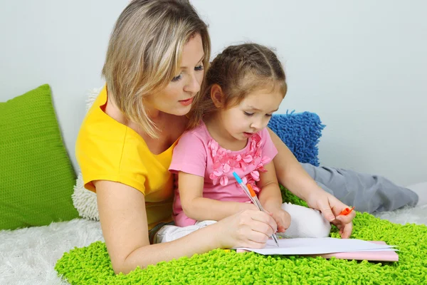 Liten flicka med mamma läsa bok i sängen — Stockfoto