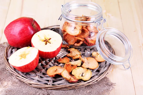 Gedroogde appels in glazen pot, op een houten achtergrond kleur — Stockfoto