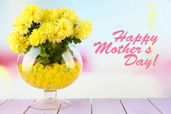 Vackra blommor i vas med hydrogel på bordet på ljus bakgrund — Stockfoto