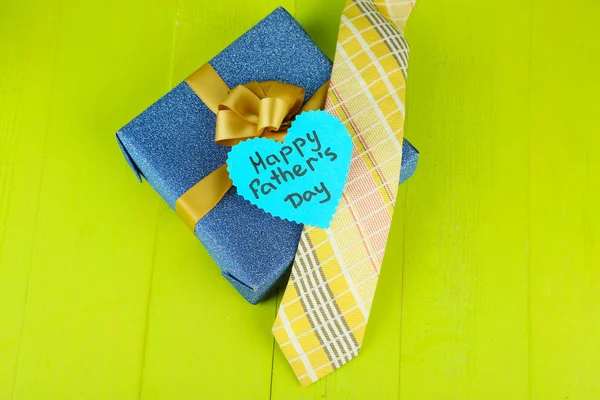 Étiquette Happy Fathers Day avec boîtes cadeaux et cravate, sur fond en bois — Photo