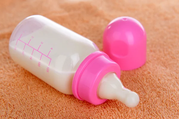 Baby bottle with milk on towel background — Stock Photo, Image