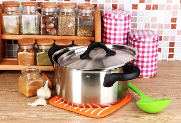 Pot and spices in kitchen on table on mosaic tiles background — Stock Photo, Image