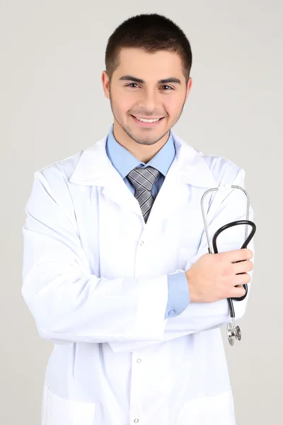 Man dokter staan op grijze achtergrond — Stockfoto