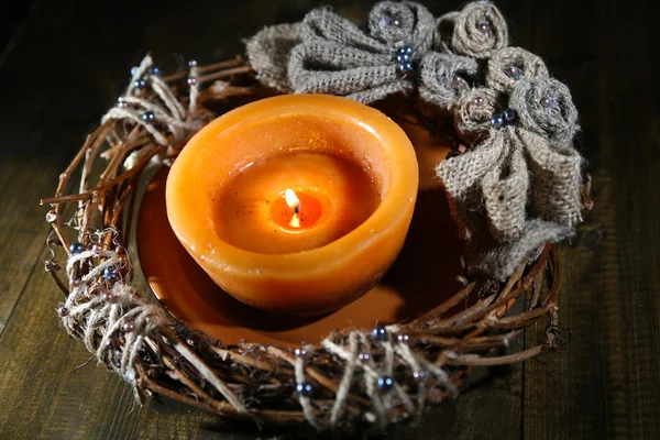 Brennende Kerze mit Adventskranz auf Holzgrund — Stockfoto