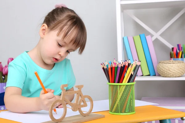 Petite fille dessine assis à table dans la chambre — Photo