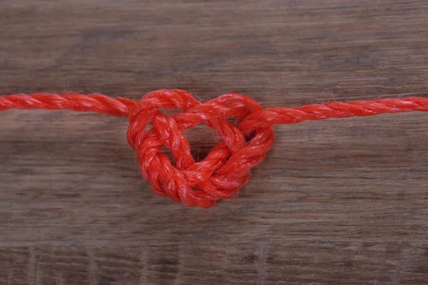 Forma del corazón de la cuerda, sobre fondo de madera de color — Foto de Stock