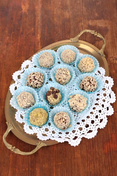 Set van chocolade snoepjes, op dienblad, op houten achtergrond — Stockfoto