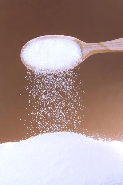 Sugar on brown background — Stock Photo, Image