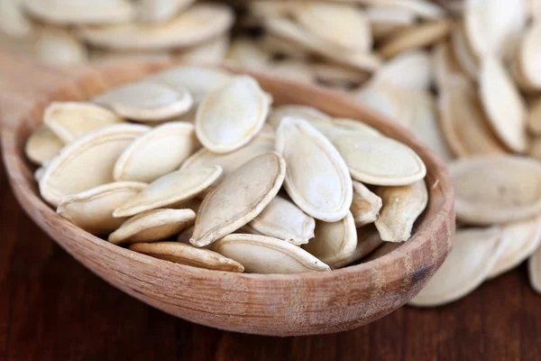 Pumpkin seeds in spoon on table close up — Stock Photo, Image