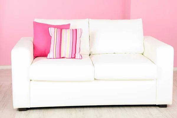 Sofá blanco en la habitación sobre fondo rosa — Foto de Stock