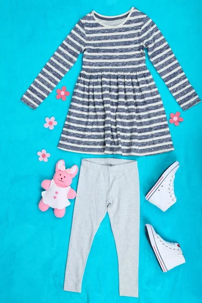 Piękne ubrania dla dziewczynki na niebieskim tle — Zdjęcie stockowe