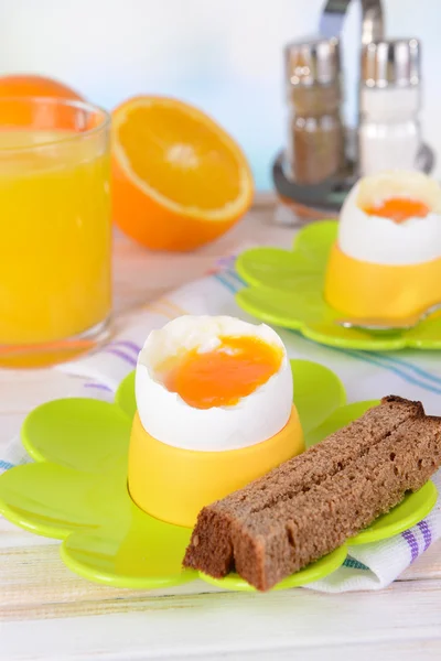 Boiled eggs in egg cups on table on light background — Stock Photo, Image
