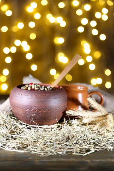 Pot with kutia - traditional Christmas sweet meal in Ukraine, Belarus and Poland, on wooden table, on bright background — Stock Photo, Image