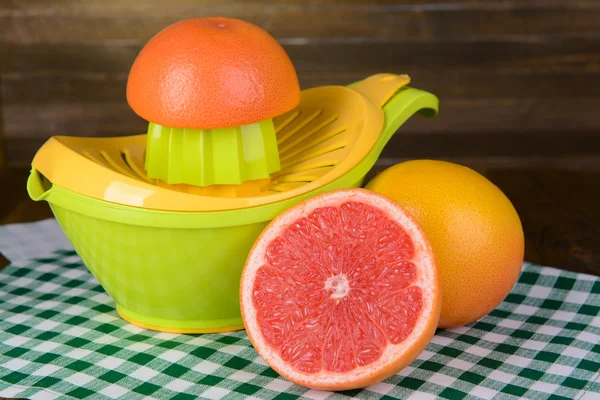 Citruspress och grapefrukt på bordet på trä bakgrund — Stockfoto