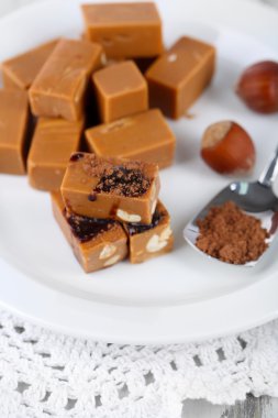 Many toffee on plate on napkin close-up clipart