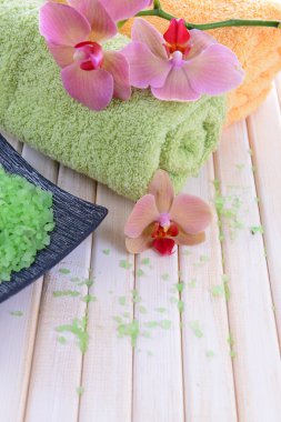 güzel çiçek ile natürmort orkide çiçek, havlu ve deniz tuzu, renk ahşap arka plan üzerine bir kase