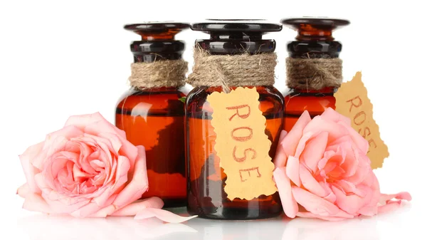 Bottiglie di olio e rose isolate su bianco — Foto Stock