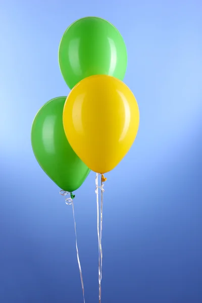 Three colorful balloons on blue background — Stock Photo, Image