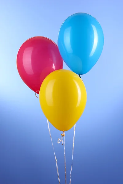 Trois ballons colorés sur fond bleu — Photo