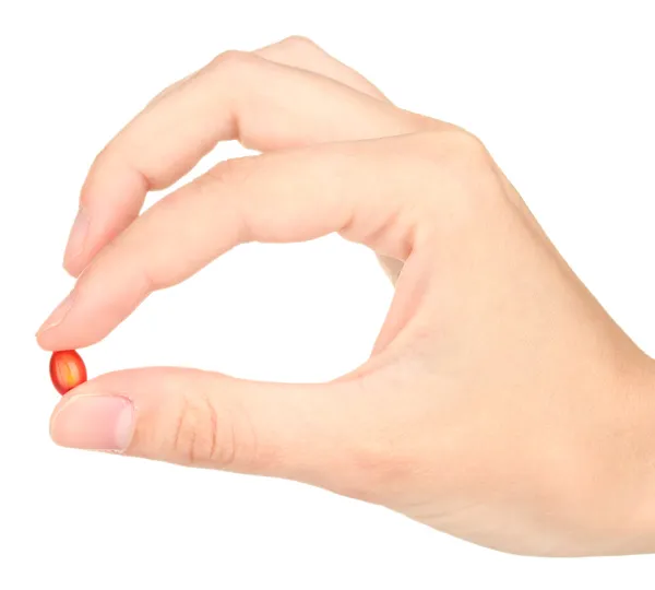 Жіноча рука тримає червону таблетку на білому тлі крупним планом — стокове фото