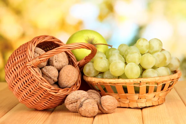 Cépages dans le panier avec noix sur table en bois — Photo