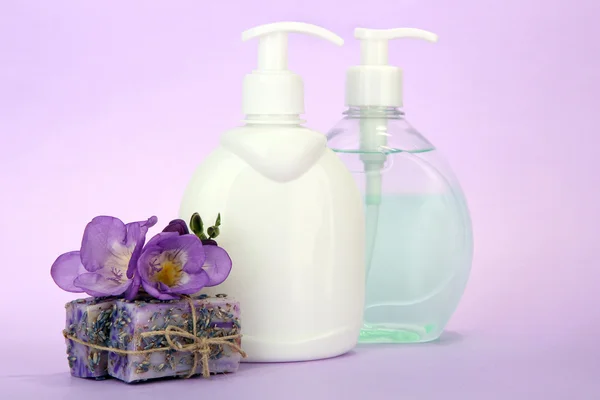 Liquid and hand-made soaps on purple background — Stock Photo, Image