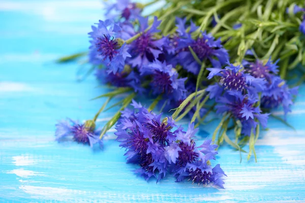 Beautiful bouquet of cornflowers on blue wooden background — Stock Photo, Image