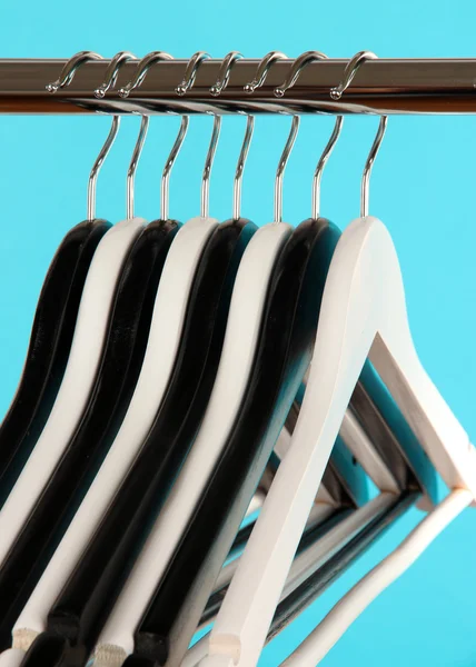 Black and white clothes hangers on color background — Stock Photo, Image