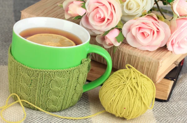 La taza del té con la cosa tejida en él se acercan —  Fotos de Stock