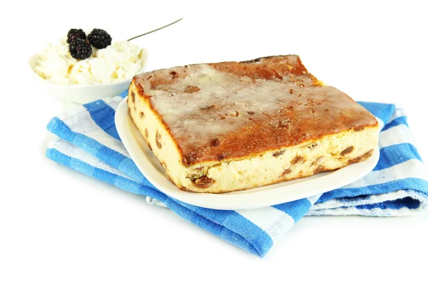 Caçarola de queijo com passas na placa em guardanapo isolado em branco — Fotografia de Stock
