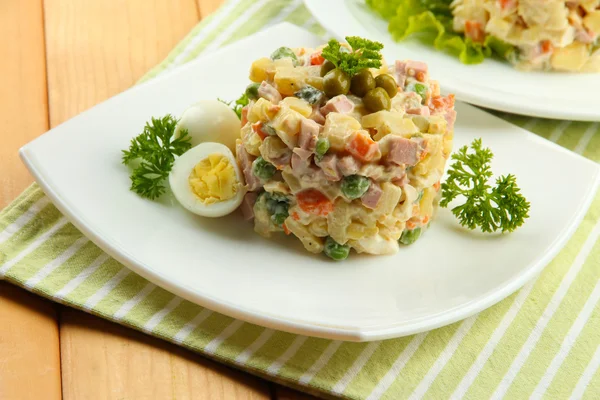 Salada tradicional russa Olivier, em guardanapo de cor, em fundo de madeira — Fotografia de Stock