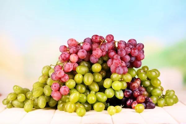 Uvas maduras verdes y moradas sobre mesa de madera sobre fondo natural —  Fotos de Stock