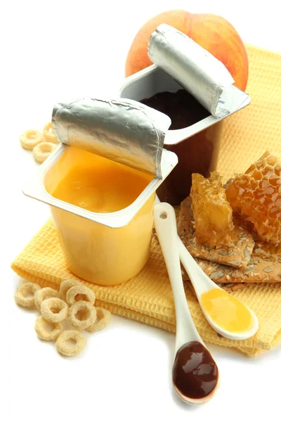 Tasty desserts in open plastic cups and honey combs, fruits, on napkin, isolated on white — Stock Photo, Image