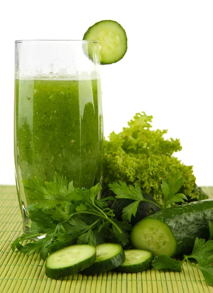 Vidro de suco de legumes verde na esteira de bambu no fundo branco — Fotografia de Stock