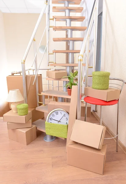 Pila di cartoni vicino alle scale: concetto di casa in movimento — Foto Stock