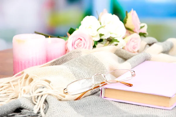 Sammansättning med gammal bok, glasögon, ljus, blommor och pläd på ljus bakgrund — Stockfoto