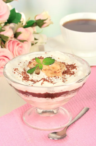 Deliciosa sobremesa com banana e caramelo na mesa no fundo claro — Fotografia de Stock