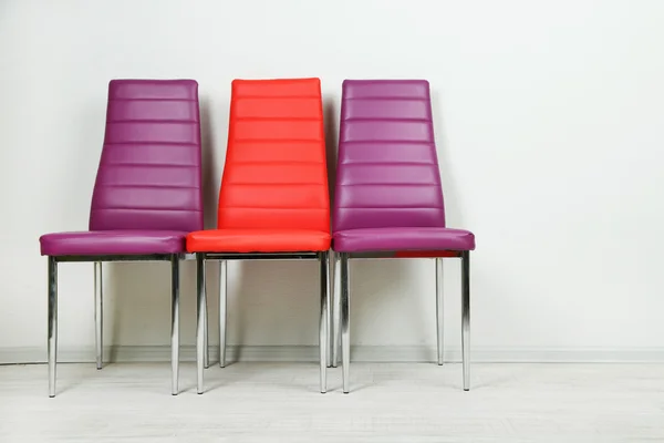 Modern color chairs on wall background — Stock Photo, Image