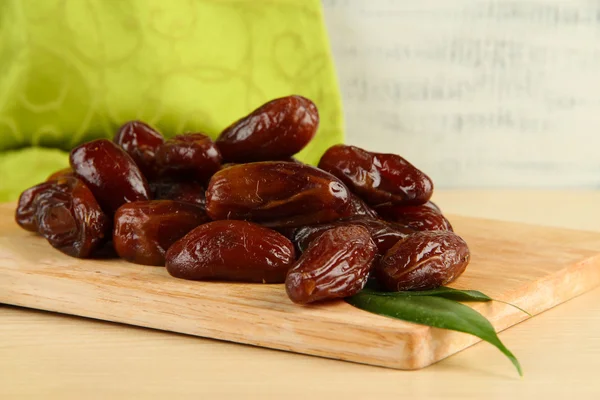 Dates séchées sur support en bois sur table sur fond de tissu — Photo