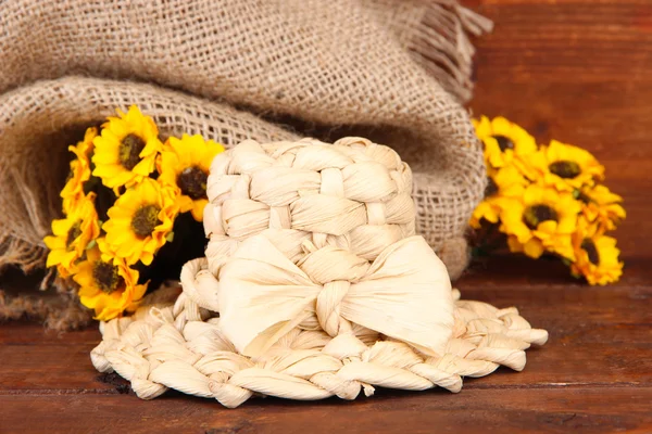 Sombrero de paja pequeño con flores, sobre mesa de madera —  Fotos de Stock