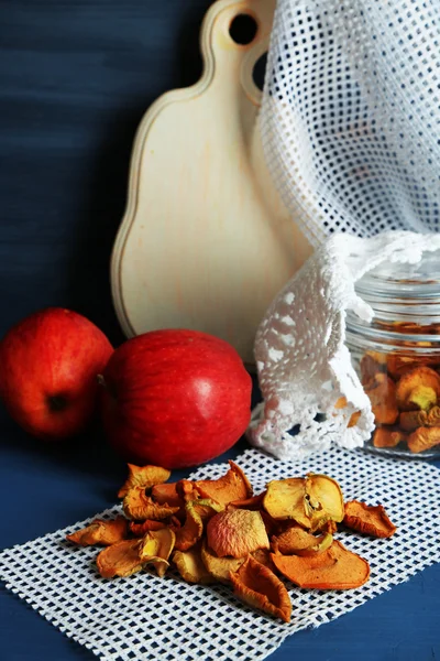 Tørrede æbler i glas krukke, på farve træ baggrund - Stock-foto