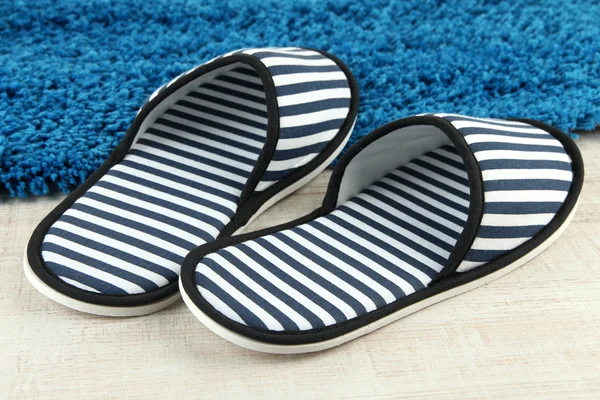 Striped slippers on floor background — Stock Photo, Image