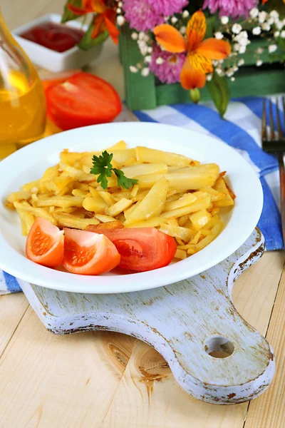 Rossig gebakken aardappelen op plaat op houten tafel close-up — Stockfoto