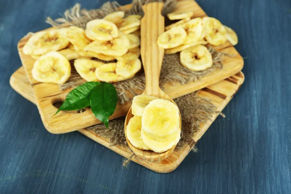 Čerstvé a sušené banánové řezy na prkénko, na dřevěné pozadí — Stock fotografie