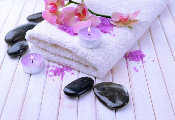 güzel çiçek ile natürmort orkide çiçek, havlu ve deniz tuzu, renk ahşap arka plan üzerine bir kase