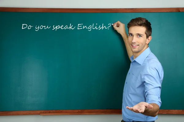 Junge Lehrerin in der Nähe der Tafel im Klassenzimmer — Stockfoto